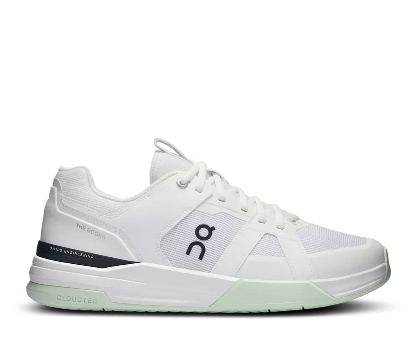 White athletic shoe with green sole on a white background
