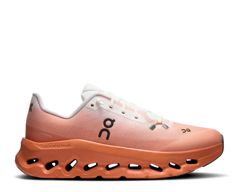 Peach-colored running shoe with white accents on a white background